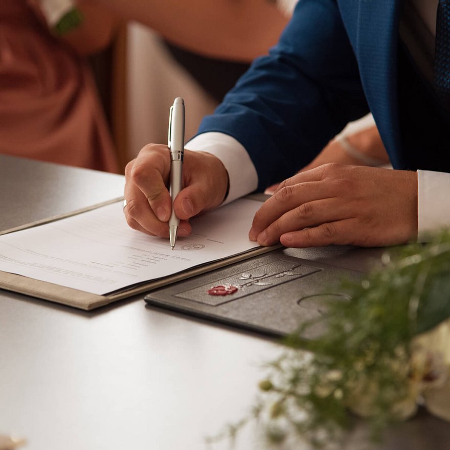 Ein Ehepaar unterschreibt im Standesamt ihre Eheschließung